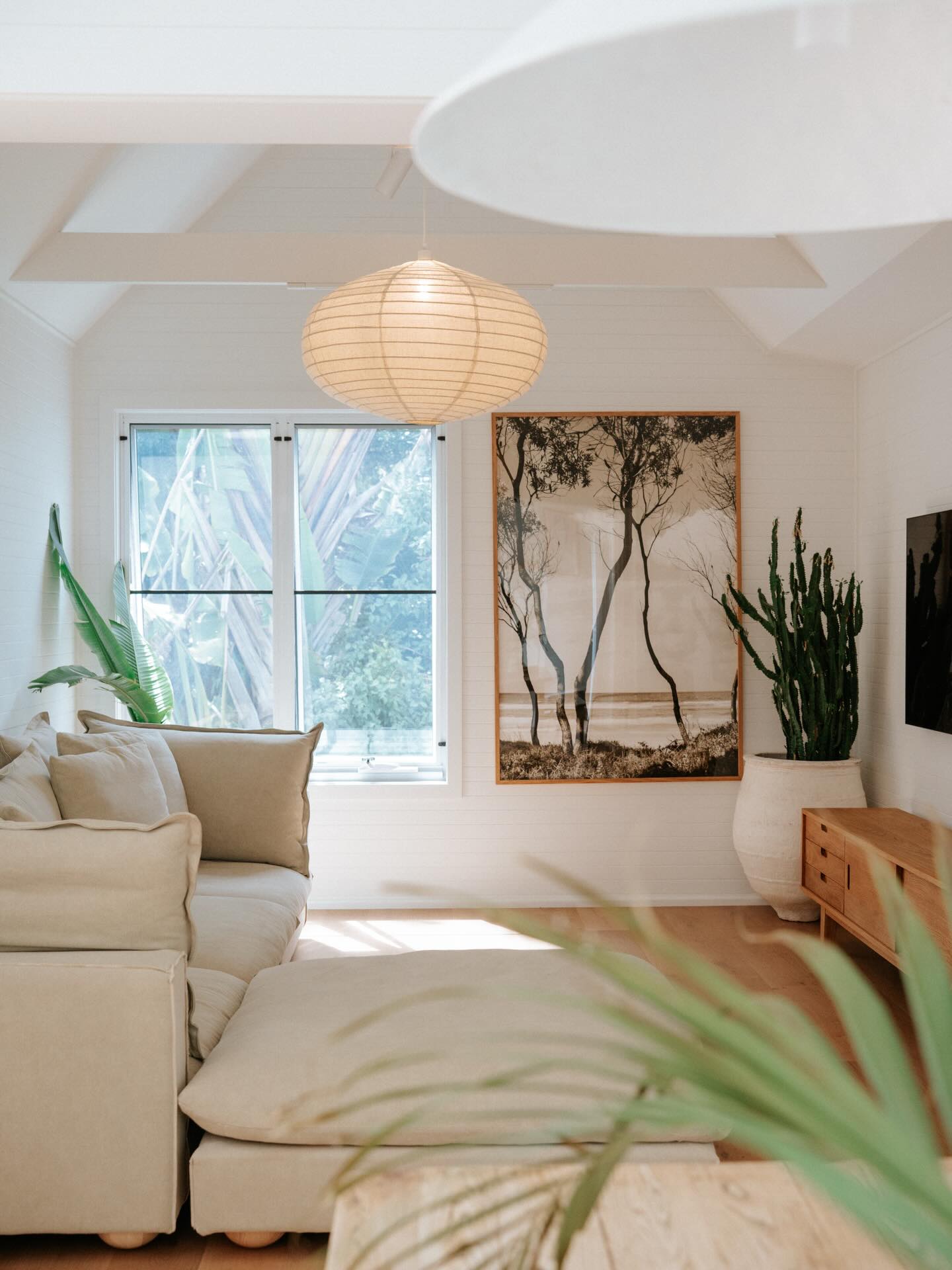 Living room adjoining the kitchen, with a paper pendant and linen sofa