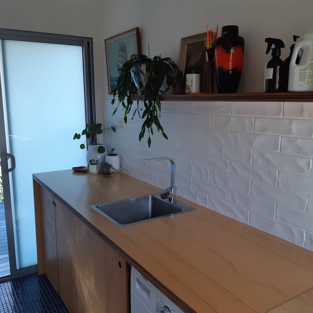 Laundry with a marine ply benchtop, floating shelf and tiled splashback